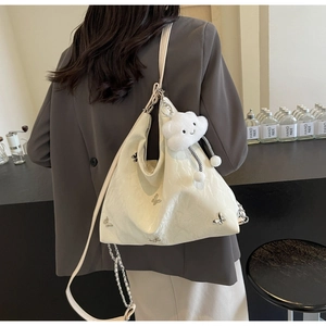 Detail of off-white hobo bag with silver butterflies and plush cloud pendant charm