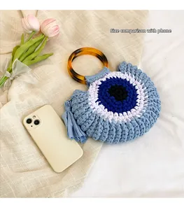 Maatvergelijking van handgemaakte gehaakte handtas met evil eye motief en kwastjes