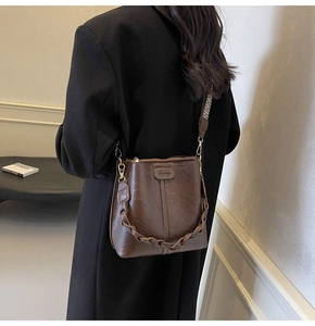 Detail of vintage brown bucket bag with wide jacquard strap and leather texture