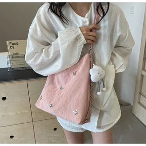 Pink shoulder bag with silver butterfly print and white cloud charm on metal chain strap