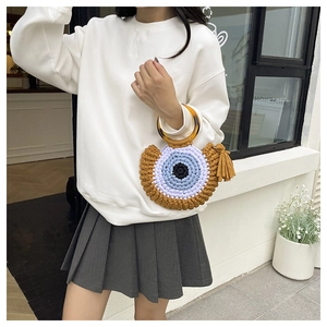 Detail of handmade crochet handbag with amber-textured handle and Evil Eye motif