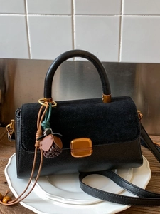Elegant black leather handbag with suede flap and acorn charm for women