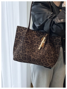Dettaglio della borsa tote leopardata con elegante nappa di perline di legno colorate