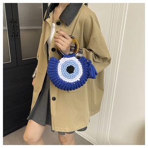 Handwoven blue cotton shell bag with evil eye motif and amber resin round handles