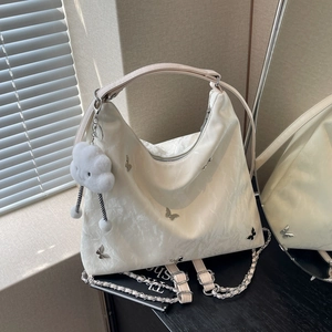 Chic off-white hobo bag with silver butterfly charms and cloud plush keychain