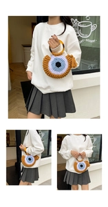 Detail of crochet evil eye handbag with resin handles and decorative tassel fringe