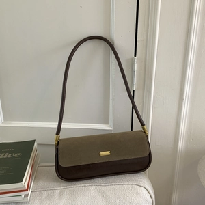 Detail of olive green suede and brown leather underarm bag with gold metal clasp