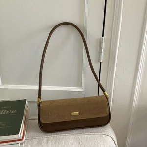 Detail of retro coffee brown patchwork underarm bag with suede flap and gold hardware