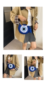 Detail of hand-woven cotton shell bag with evil eye motif and resin handle