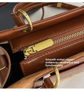 Close-up of smooth golden metal zipper and polished hardware on dark brown leather bag