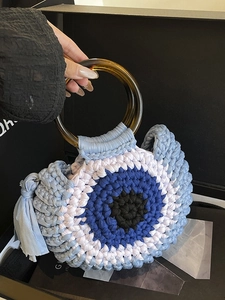 Handwoven evil eye crochet handbag with amber resin handles and stylish fringe detail