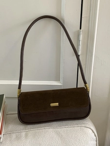 Minimalist dark brown suede baguette bag with gold accents and a slim shoulder strap