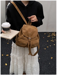 Close-up of brown vintage backpack with metal buckles and front pockets in autumn setting
