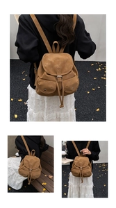 Detail of vintage brown suede backpack with buckle straps and drawstring closure