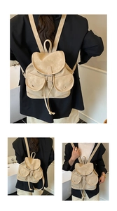 Detailed view of beige vintage backpack with front buckle pockets and drawstring closure