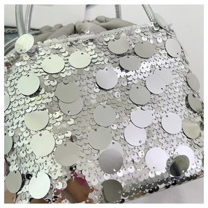 Détail macro des paillettes argentées et du cordon de serrage d'un sac de soirée chic