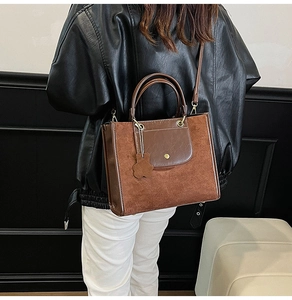 Brown vintage tote bag featuring suede finish, smooth leather trim and cute bear charm
