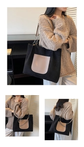 Detail of black large canvas tote bag with brown leather pocket and metal chain strap