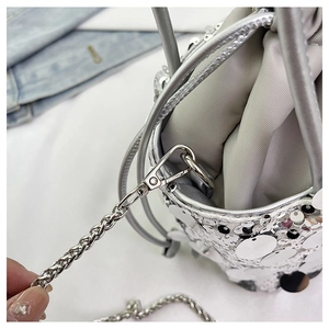 Détails macro des paillettes argentées et de la bandoulière chaîne d'un sac à cordon