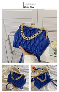 Detail view of Klein blue quilted handbag with vintage gold metal clasp and chain handle