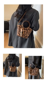 Detail of leopard print bucket bag with round handles and decorative beaded tassel