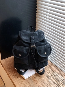 Minimalist large black suede backpack with dual front pockets and retro flap closure