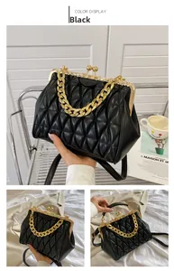 Detail view of retro black quilted bag with golden kiss-lock clasp and chunky metal chain