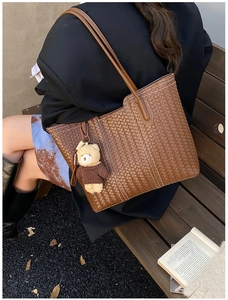 Sac cabas en cuir tressé marron avec charm ours dans un décor automnal extérieur