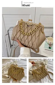 Close-up of khaki quilted leather square bag with chunky gold chain handle and vintage clasp