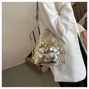 Détail du sac seau à paillettes avec doublure en soie et bandoulière en chaîne métal