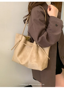 Detail shot of beige suede tote bag texture with minimalist drawstring design and strap