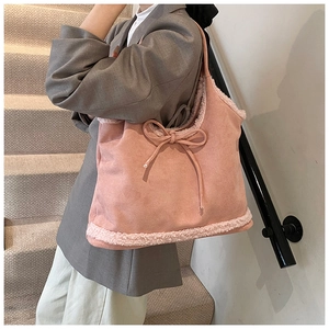 Detailed shot of pink suede tote bag with white faux fur trim and cute bow accent