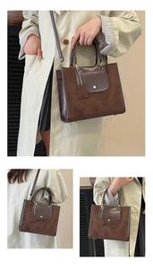 Detail view of brown vintage suede tote with gold buckle and bear charm accessory