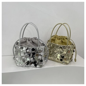 Détail de sacs seaux à paillettes avec pochettes intérieures à cordon en argent et or