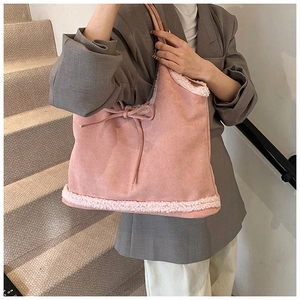 Close-up of pink suede tote bag featuring plush faux shearling trim and bow detailing