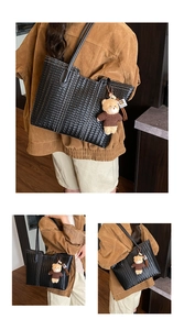 Detail of black woven tote bag featuring a plush bear charm and leather tassel accents