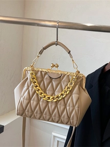 Vintage beige quilted crossbody bag with gold chain and retro clasp on studio display