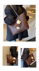 Close-up of brown woven tote bag featuring a cute teddy bear charm for daily commute