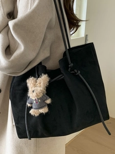 Large black suede tote bag with drawstring detail and cute plush rabbit charm