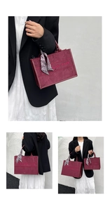 Detail view of burgundy suede tote bag with embroidery and vintage scarf wrapped handle