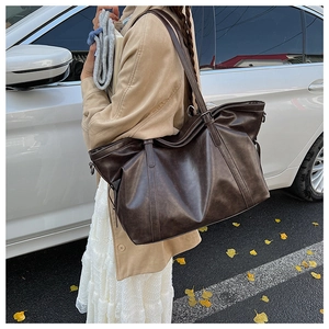 Close-up of vintage dark brown faux leather tote bag with elegant reinforced stitching