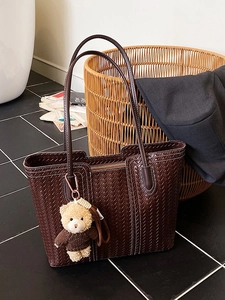 Sac fourre-tout tissé marron foncé avec un petit ours en peluche dans un cadre élégant