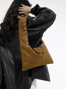 Brown vintage suede underarm bag with silver studs worn on a model in leather jacket