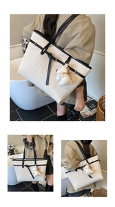 Detail of cream leopard print tote bag with black straps and plush puppy pendant charm