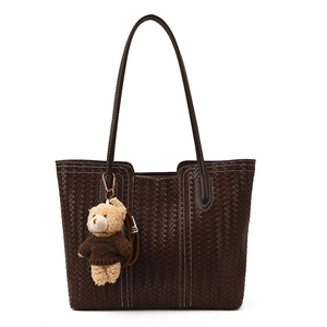 Dark brown woven tote bag with slim handles and a cute brown teddy bear charm