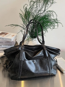 Large vintage black tote bag in glossy faux leather with retro texture for commute
