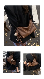 Detail view of vintage brown crossbody bag featuring soft leather texture and bear charm