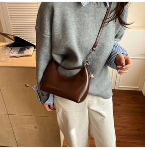 Brown leather hobo bag with silver metallic charm shown on a casual chic model outfit