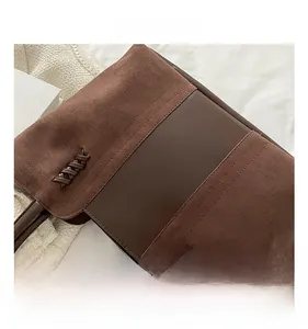 Close-up of brown tote bag featuring suede and leather patchwork with woven lace detail