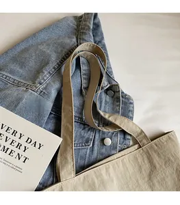 Detail of wide comfortable shoulder straps on a durable beige canvas tote bag for women